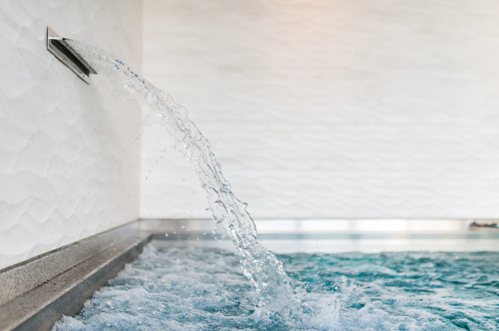 Nerezový chrlič vody zabudovaný do steny bazéna